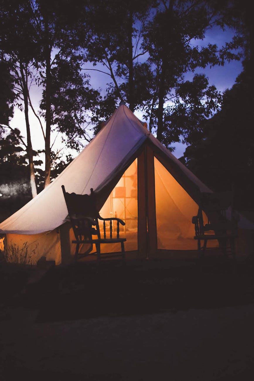 white and brown lighted cabin tent at woods
